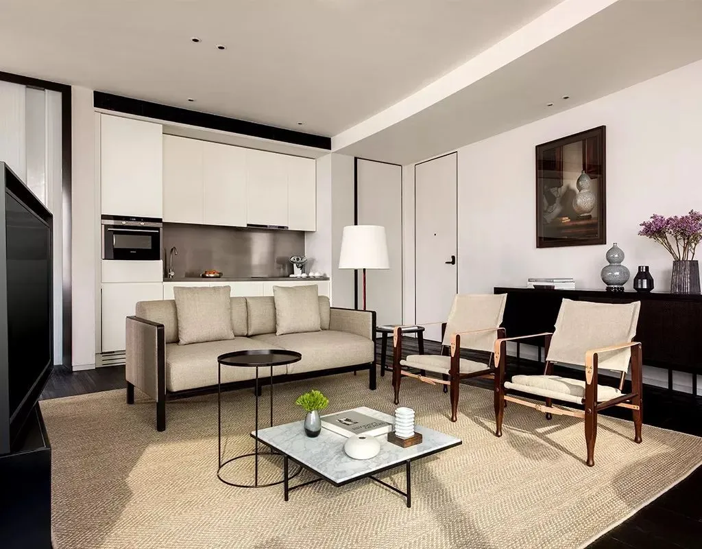 Minimalist residential living space featuring neutral-toned upholstery and wooden furniture.