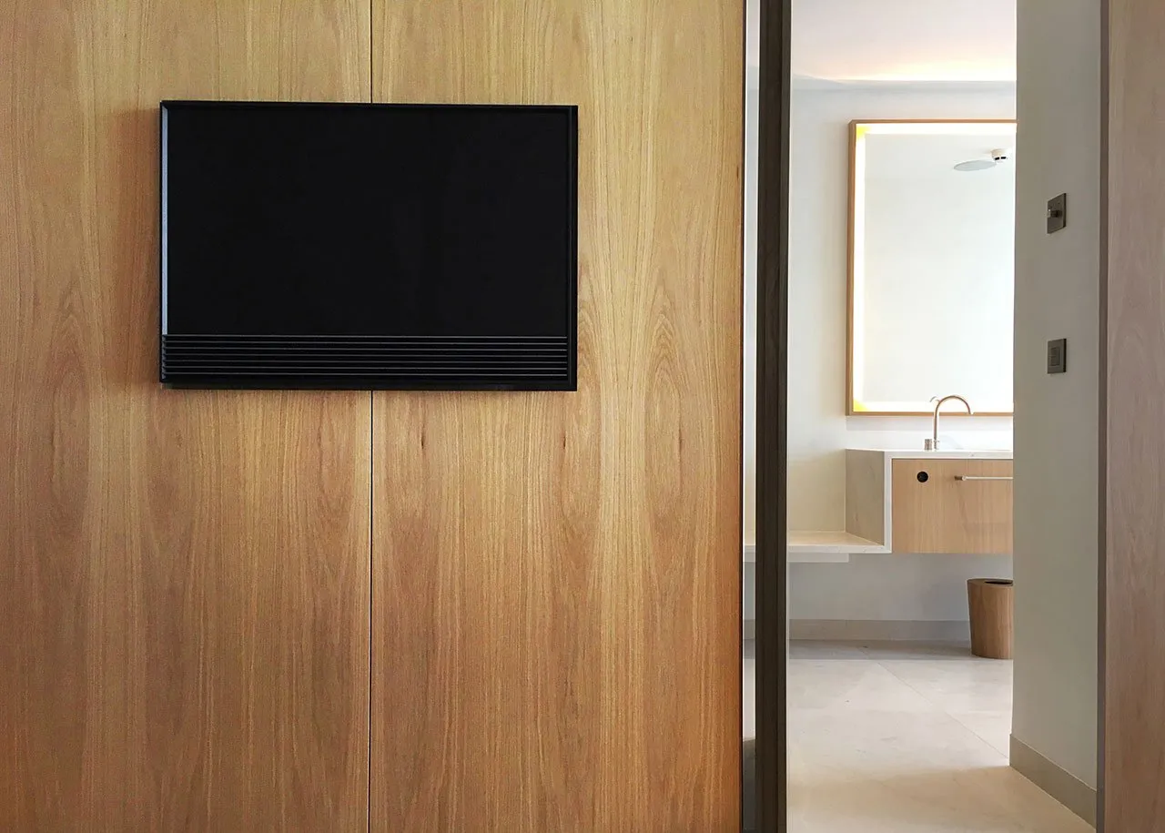 Modern minimalist bathroom with wooden elements and white fixtures.