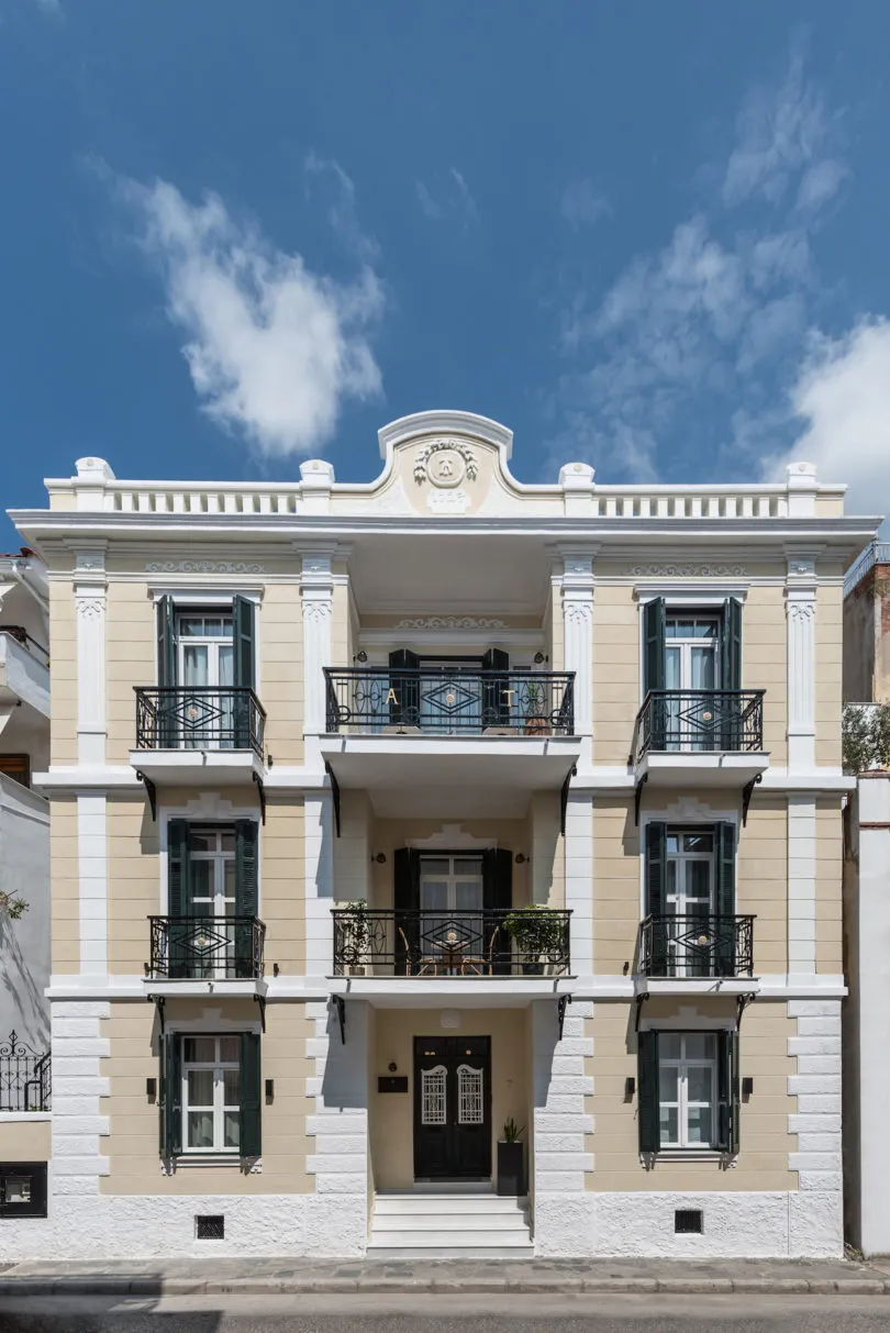 A modern residential building with concrete walls and white stucco finish.