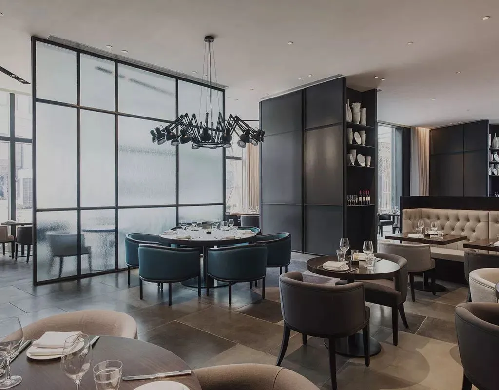 A modern restaurant interior featuring metal and glass materials.