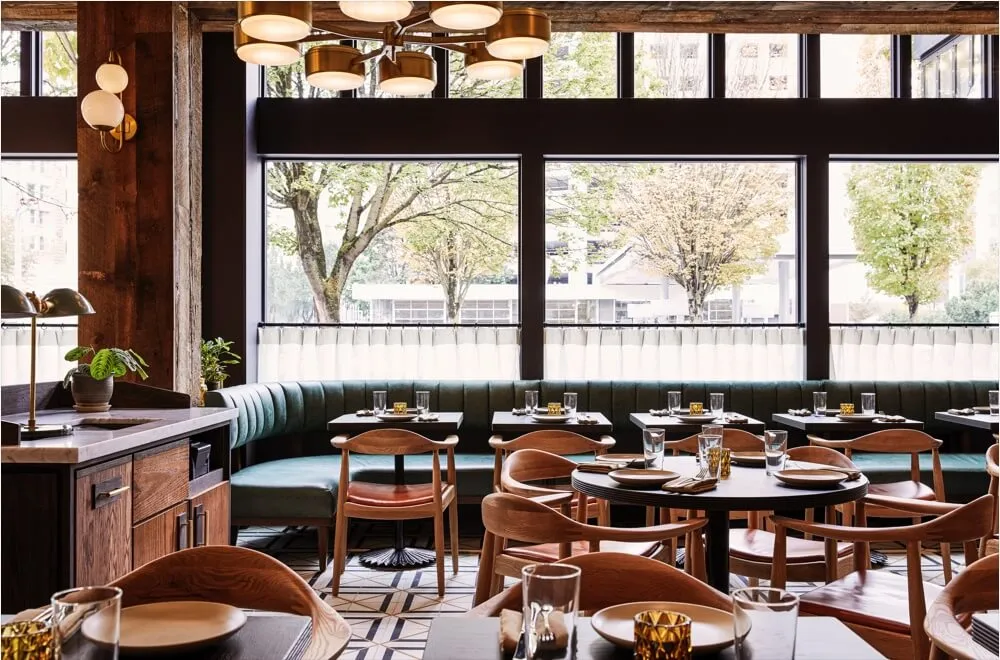 A modern, industrial-styled restaurant interior with wood, leather, and metal materials.