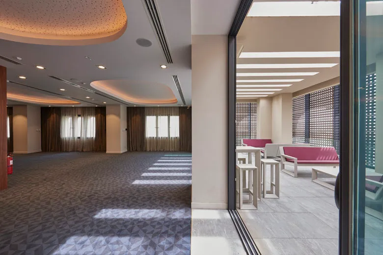 A modern conference room with concrete flooring and glass walls.