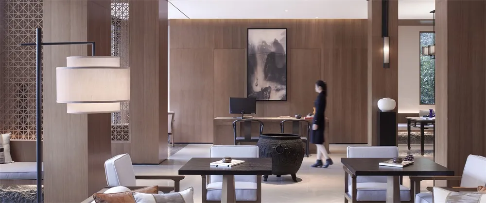 A modern hotel lobby featuring wood materials and minimalist design.