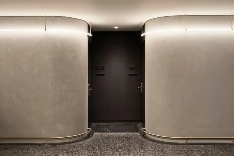 A modern lobby with concrete walls and recessed lighting.