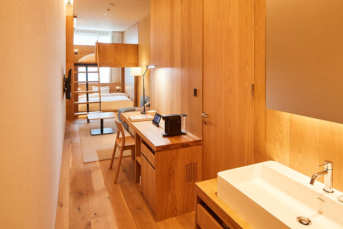 A minimalist residential suite featuring wooden furniture and a modern design.