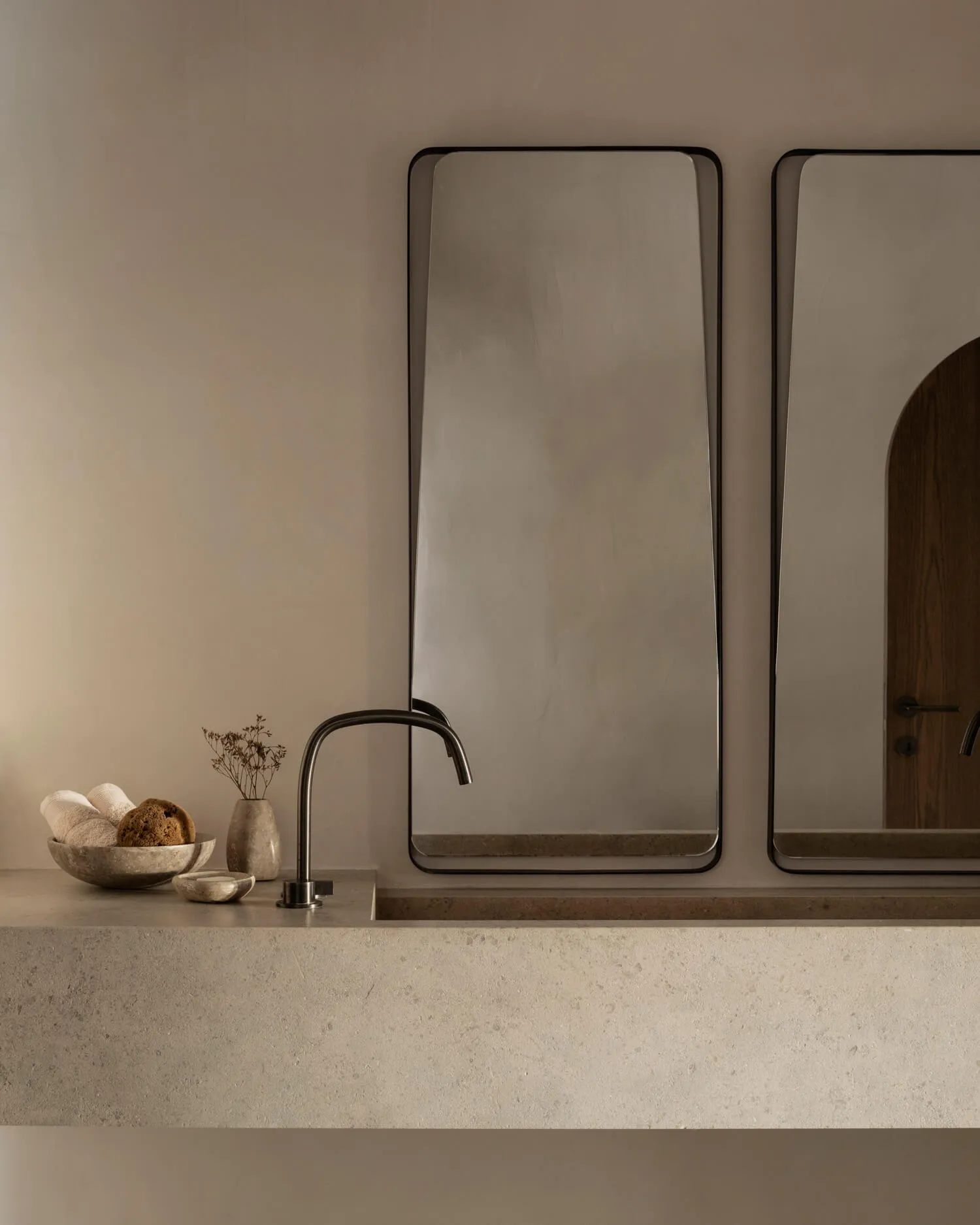 Angular modern bathroom with concrete sink and sink faucet.