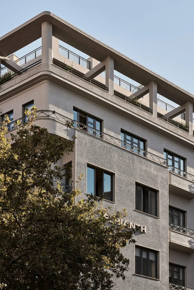 A modern building with a concrete exterior featuring geometric lines and a rooftop patio.