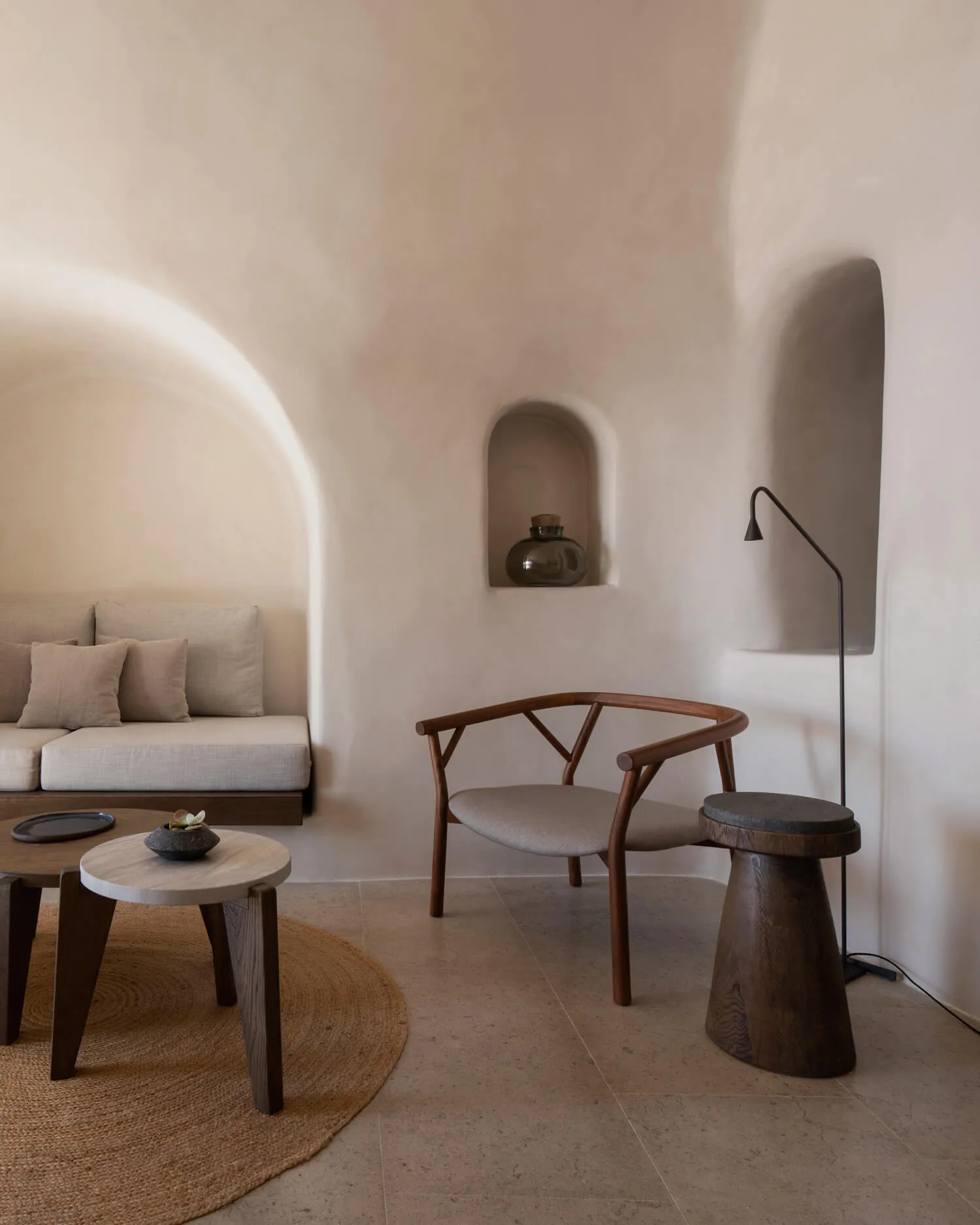 A modern minimalist living room featuring wooden furniture, leather cushions, and fabric upholstery.