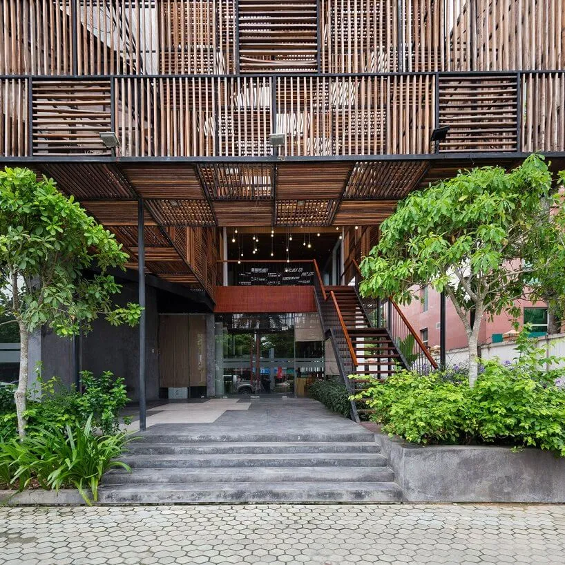 Industrial-style lobby with a wooden lattice facade and greenery