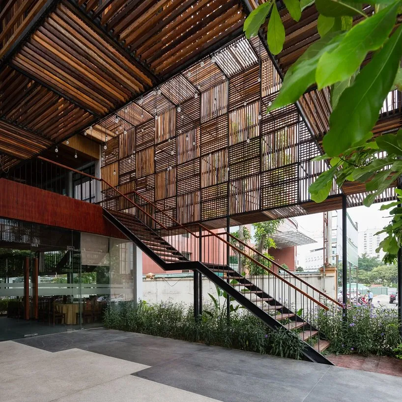 A modern industrial-style lobby entrance with wooden slats and a black staircase.