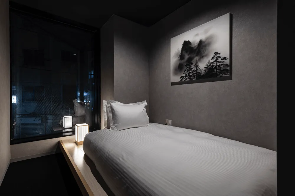 A minimalist bedroom with a textured wall material.
