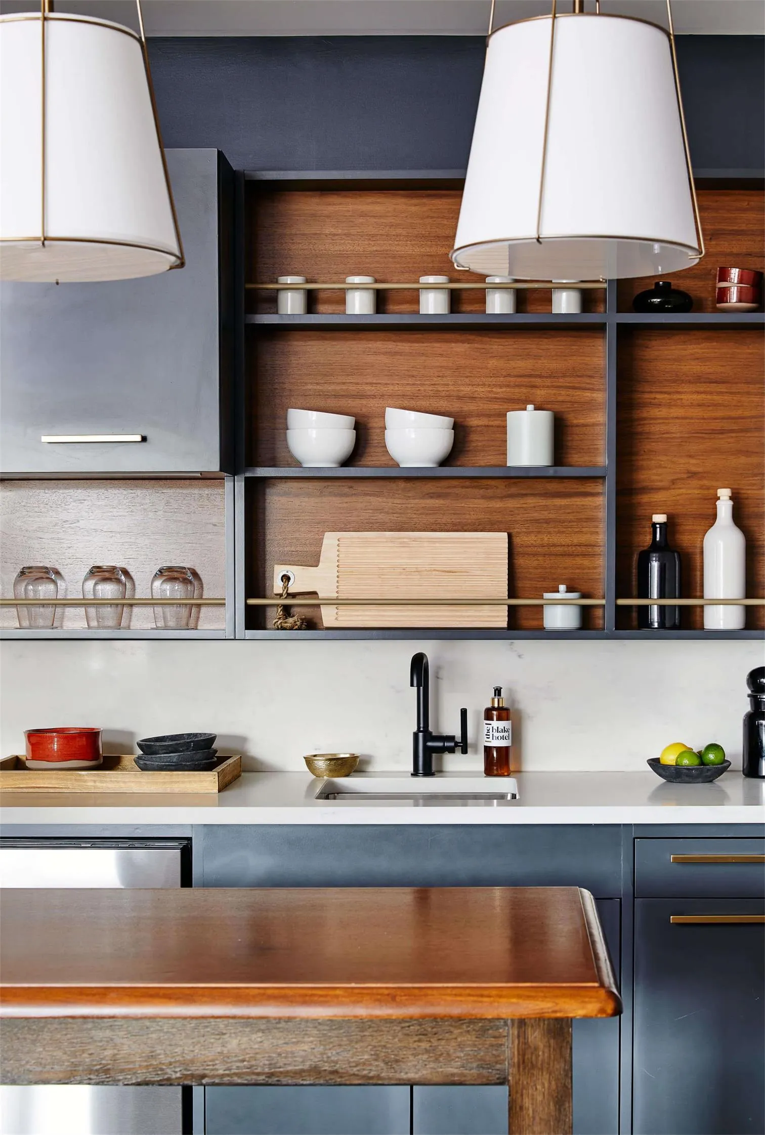 Modern kitchen with open shelving, wood finishes, and stainless steel appliances.