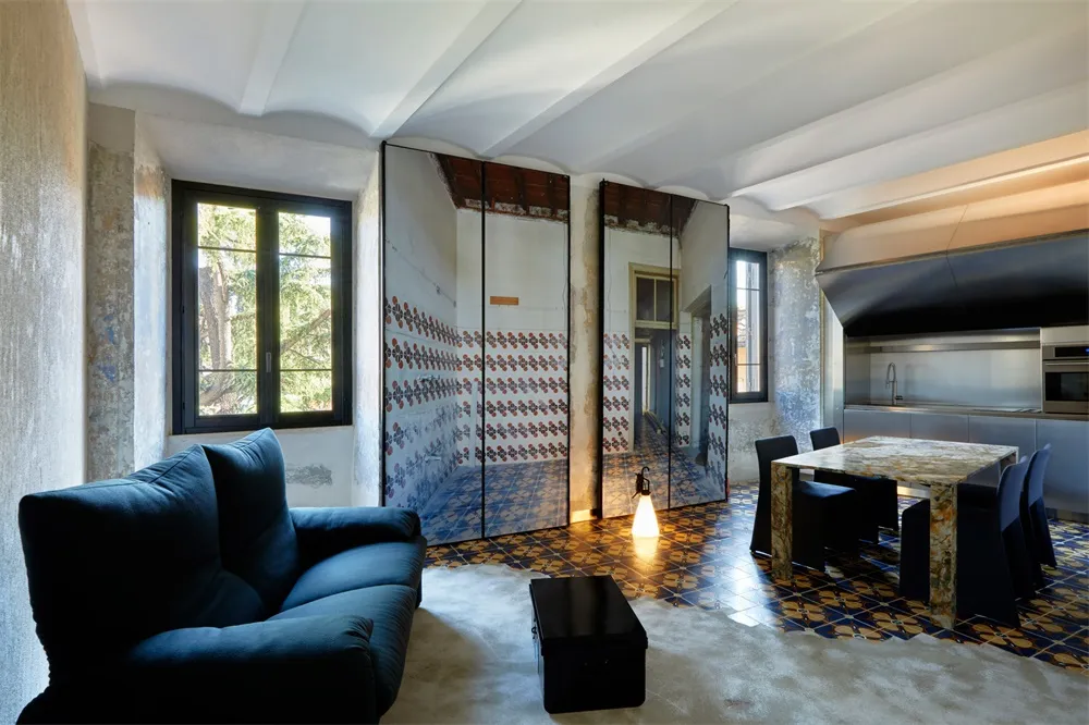A modern living room featuring a blue sofa, a coffee table, and a marble table with black chairs.