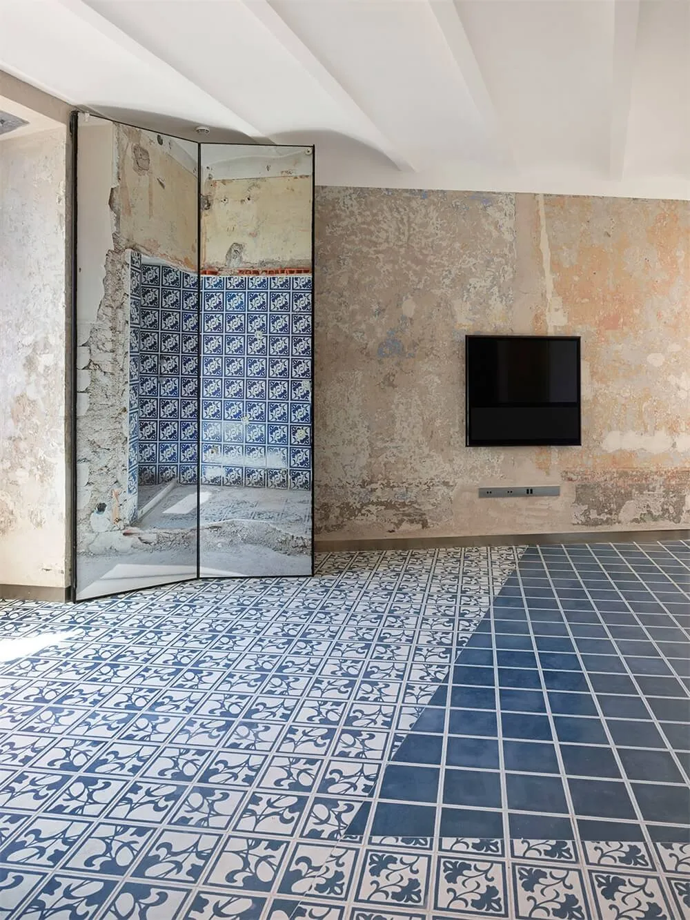 A modern living room with a tiled floor and concrete walls