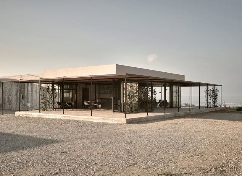 Modern minimalist residential exterior featuring exposed concrete structure and minimalist design elements.