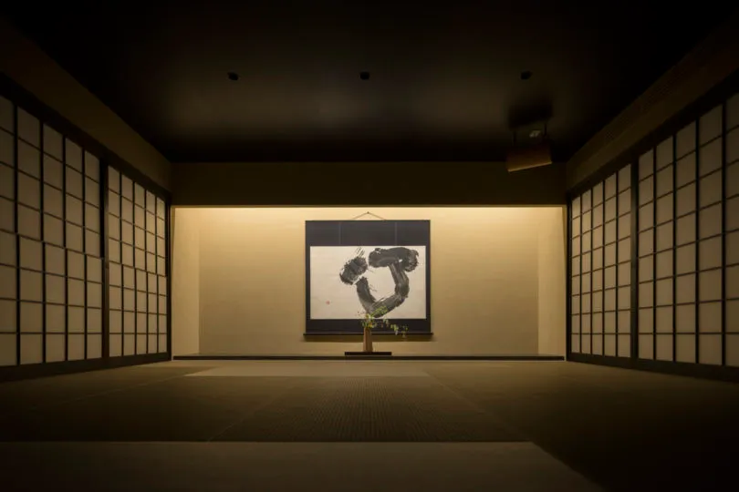 A minimalist interior features a framed piece of art displayed on a wall.