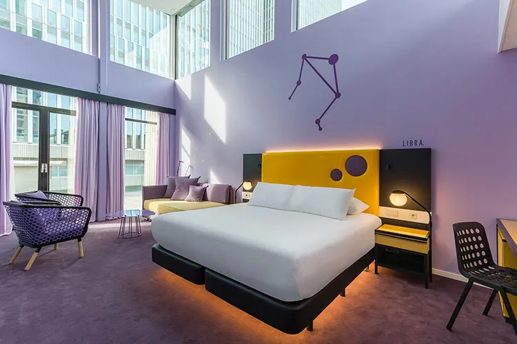 A modern bedroom featuring a purple bed with a yellow headboard, white duvet, and black nightstands.