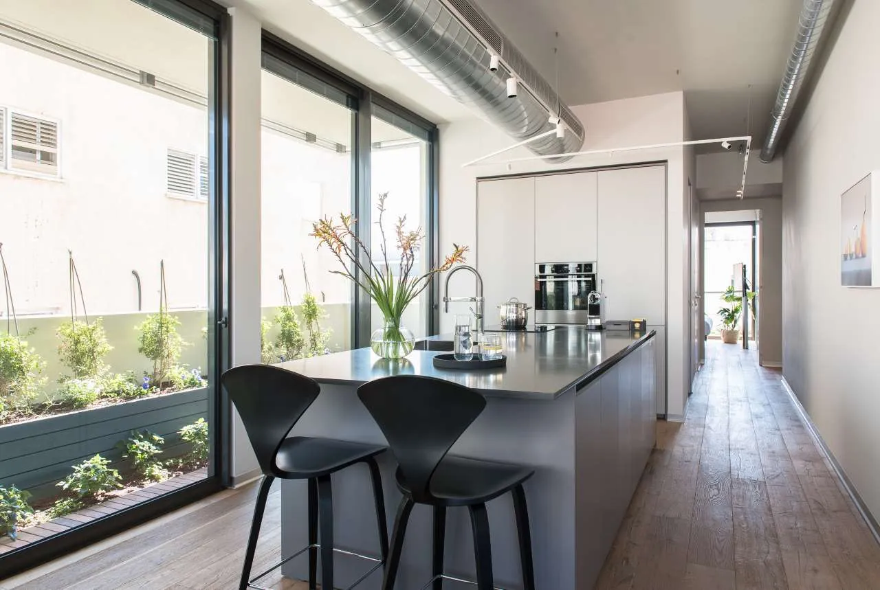 A modern kitchen featuring sleek metallic finishes and minimalistic design.