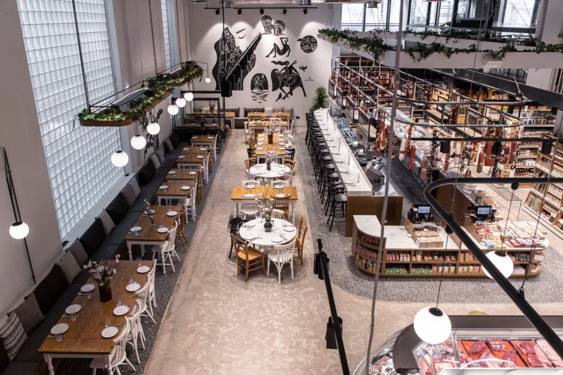 An overhead view of a modern restaurant interior with tables, chairs, and shelves.