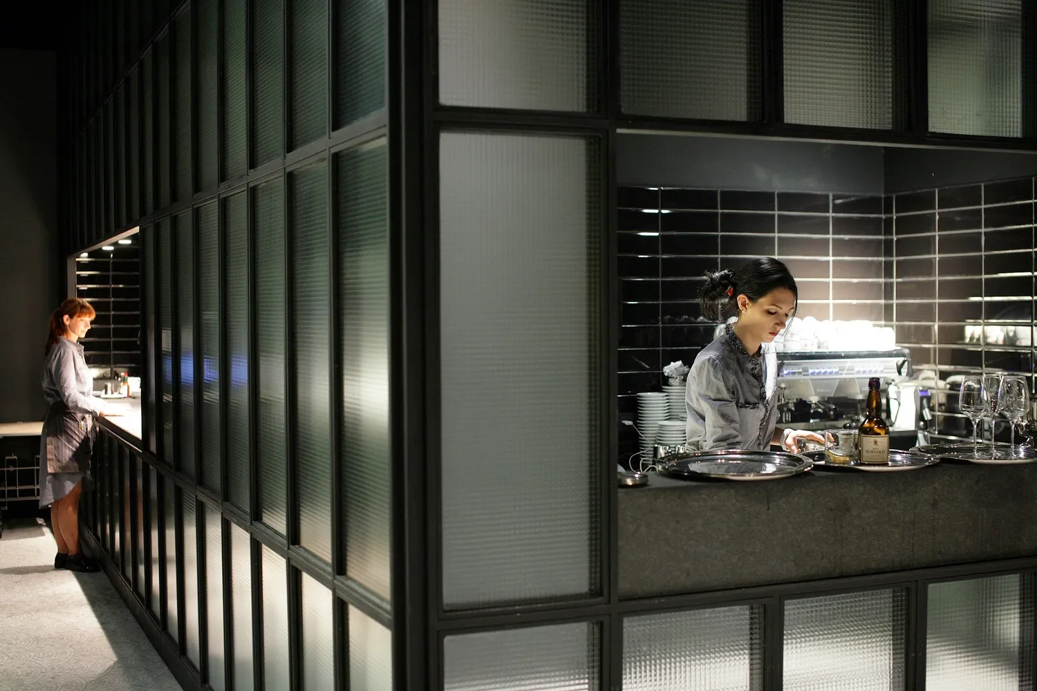 A modern restaurant interior featuring glass walls and stone surfaces.
