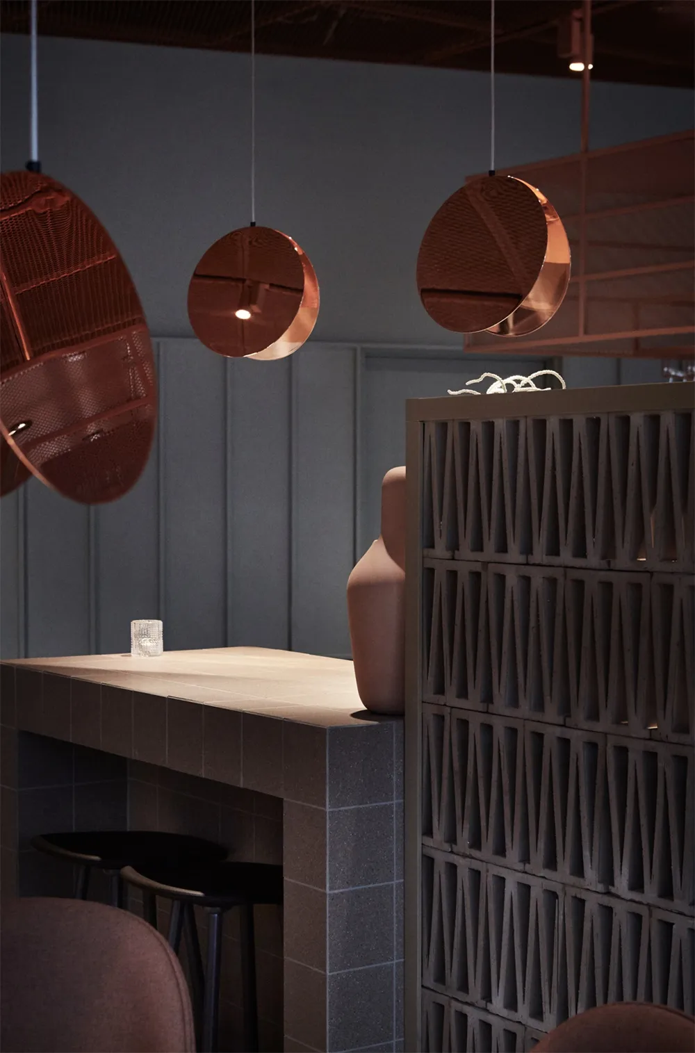Modern restaurant interior with metal counter and round lighting fixtures