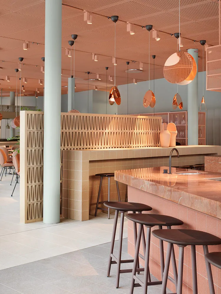 A modern restaurant bar with marble and concrete finishes and a minimalist design.