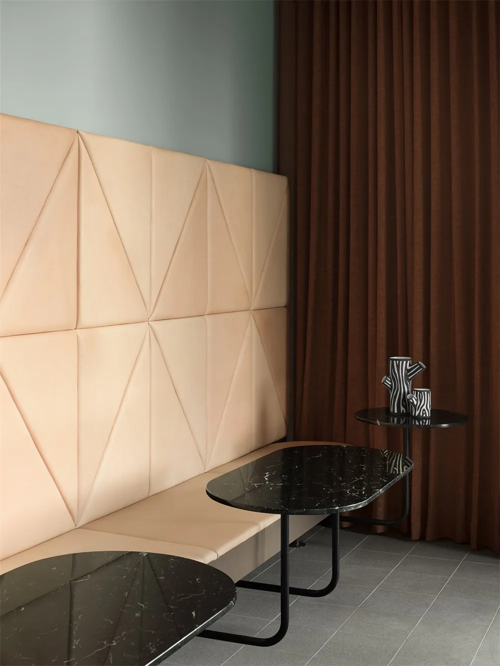 A modern coffee shop featuring marble tables, leather seating, and sleek metal tables.