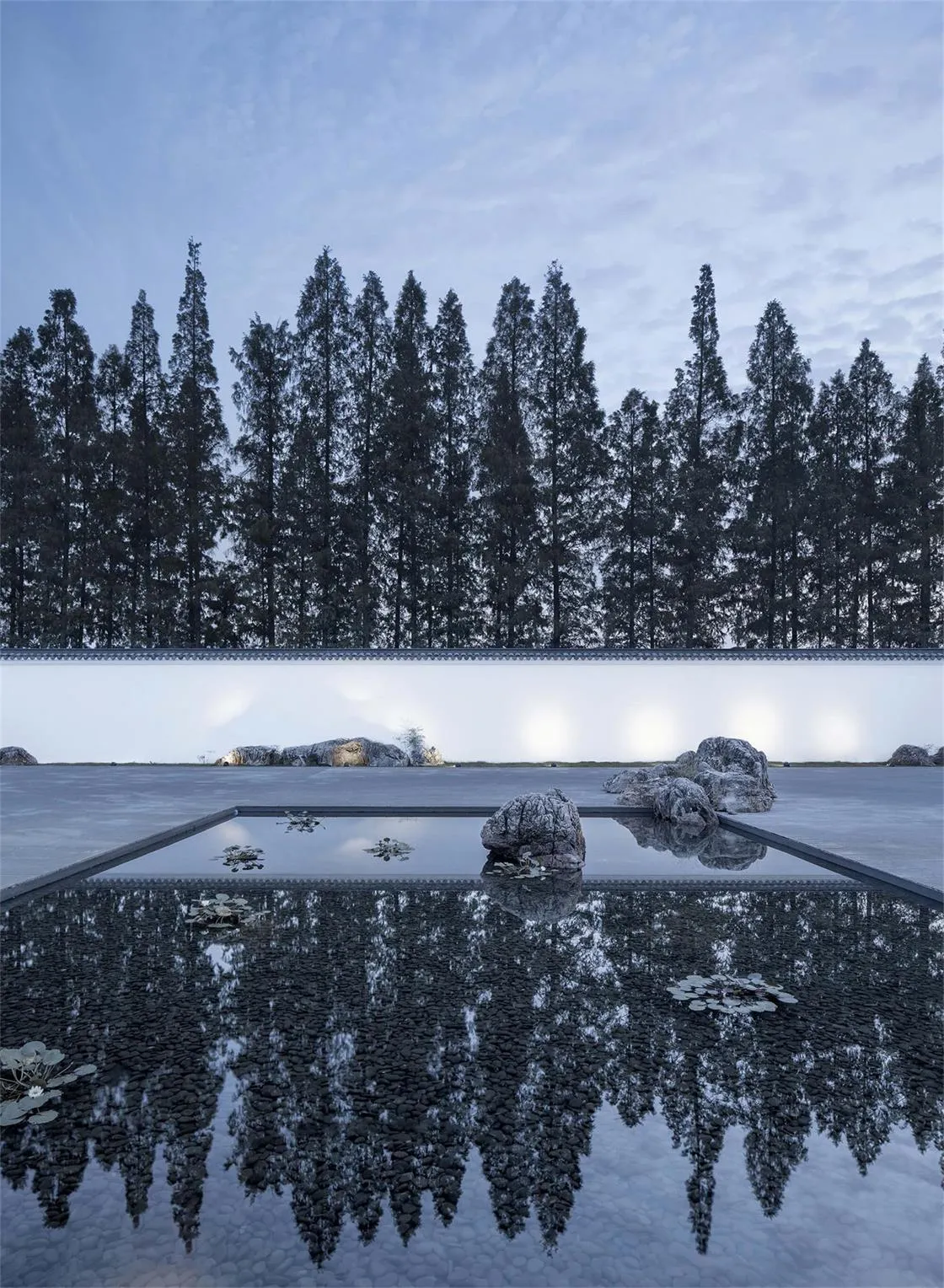 A serene minimalist landscape featuring concrete pavement, water reflections, and stone accents.