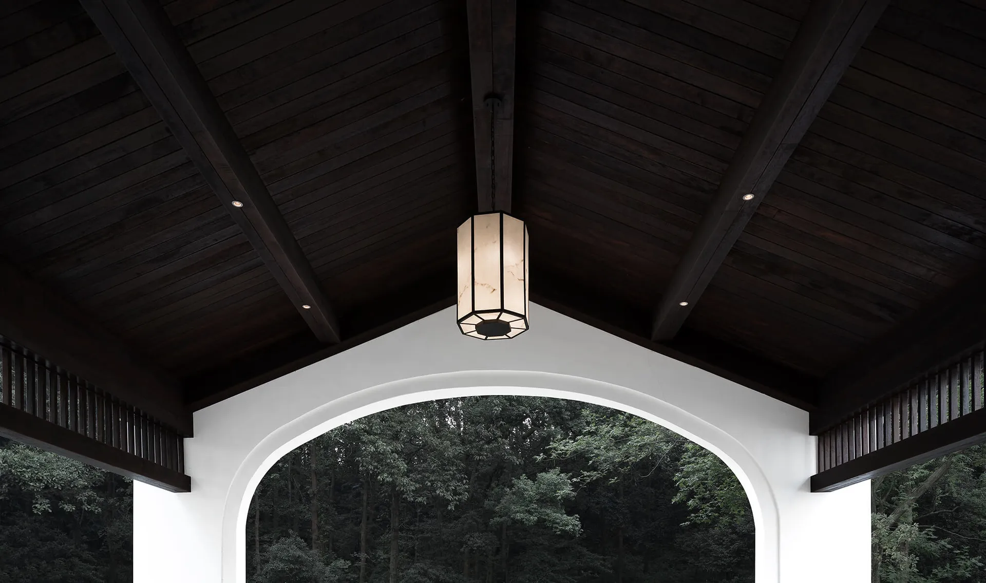 A beautifully designed wooden ceiling with a lantern hanging from it, providing warm lighting.
