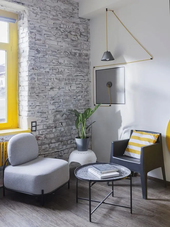 Modern, industrial-styled living room with exposed concrete and brick walls, featuring minimalist furniture.