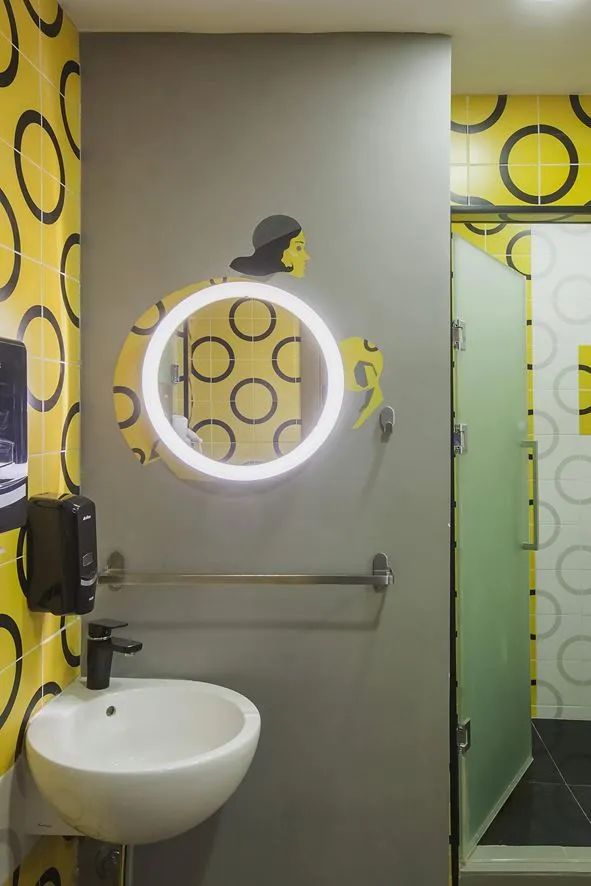Modern, minimalist retail bathroom with bold, striped yellow and black tile pattern.