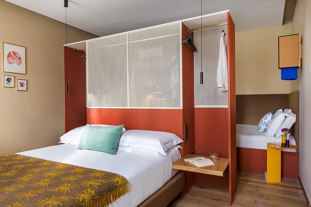 Modern minimalist bedroom featuring a metal-framed wooden bed, a foldable desk, and a small side table.