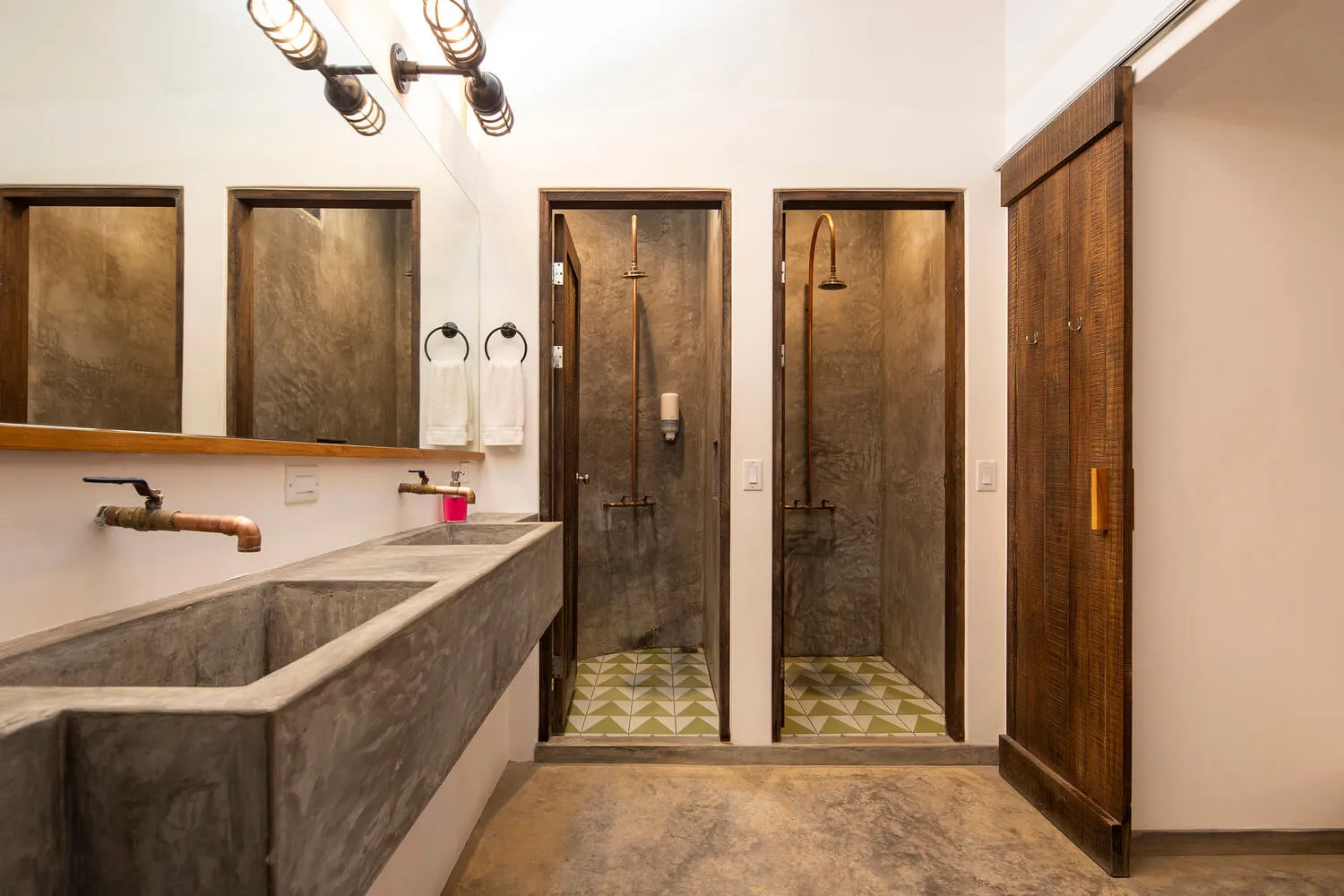 Industrial-style bathroom featuring concrete surfaces and metallic elements.