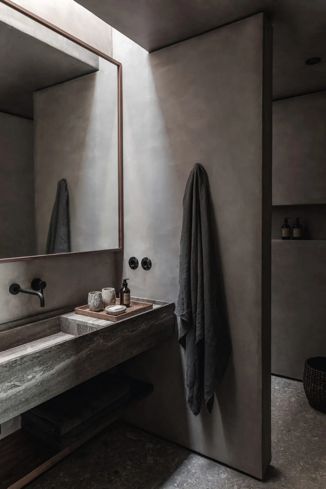 Modern bathroom with concrete walls, a floating vanity, and a wall-mounted faucet. Features minimalist design with a large mi