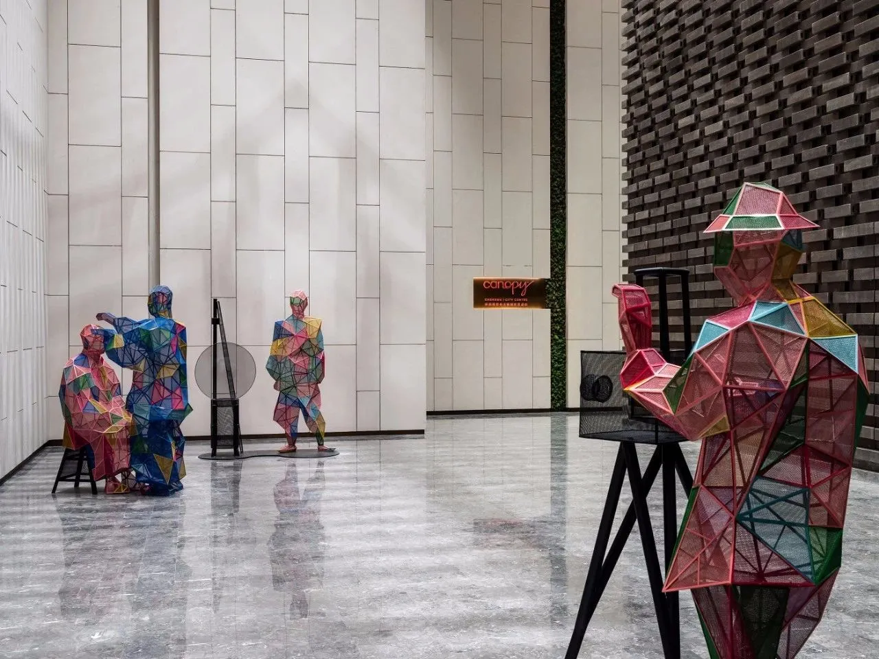 Three-dimensional geometric metal sculptures in a modern interior setting.
