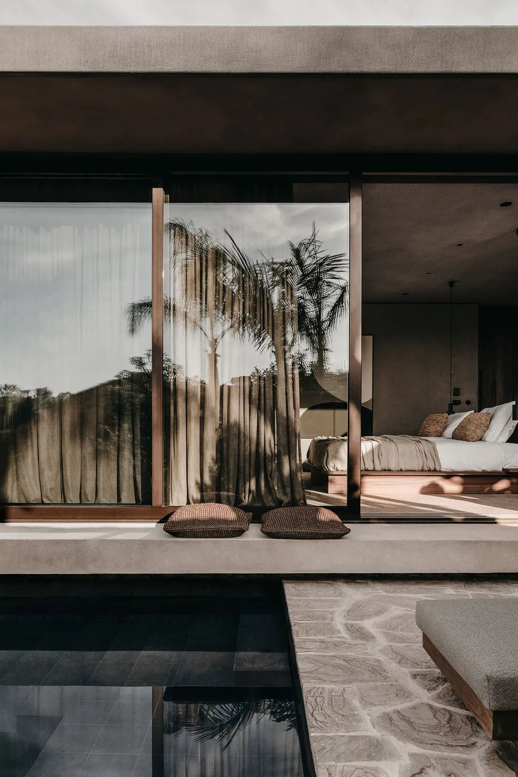 Modern minimalist bedroom featuring concrete and glass materials.