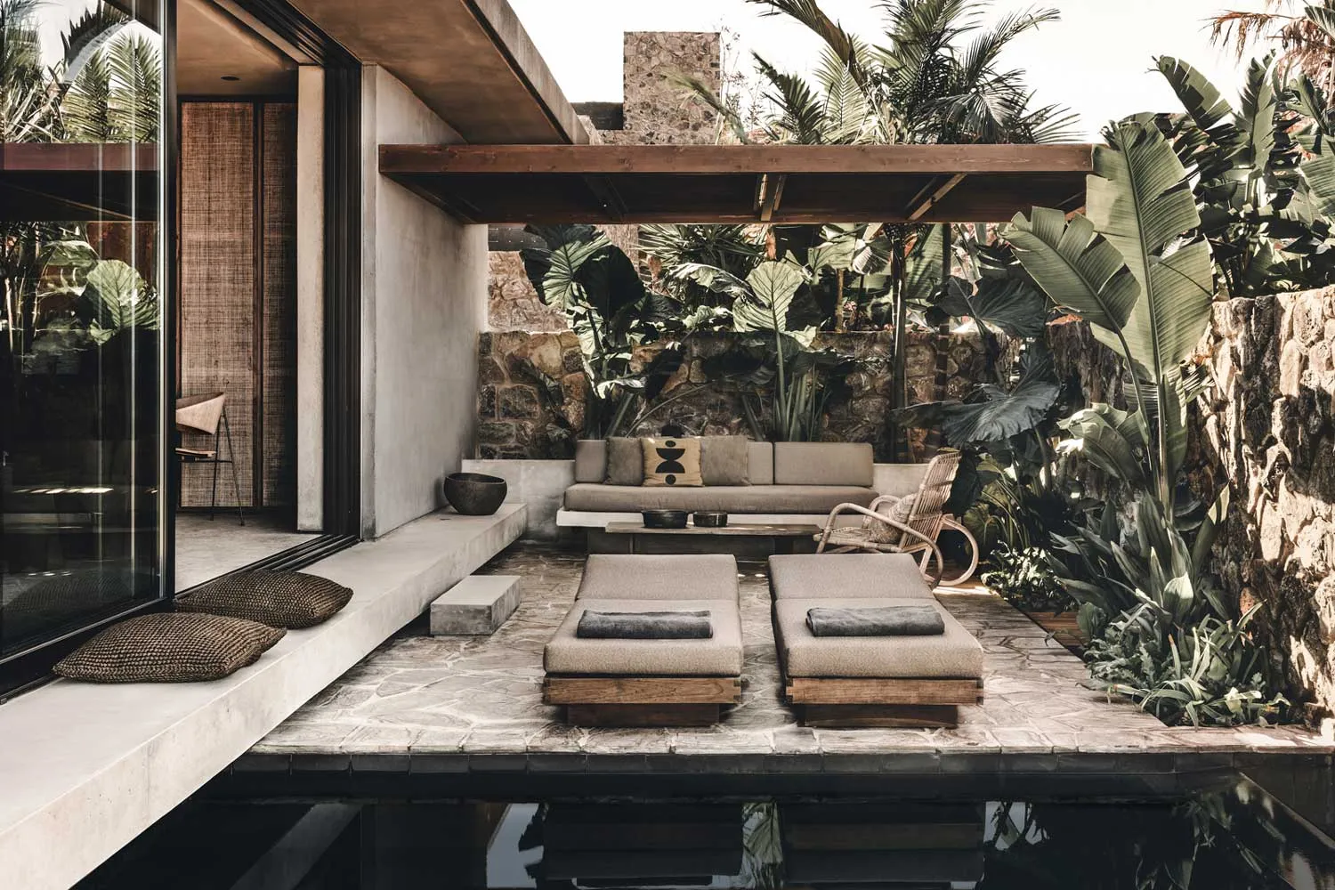 Outdoor patio with modern minimalist design featuring concrete and stone materials.