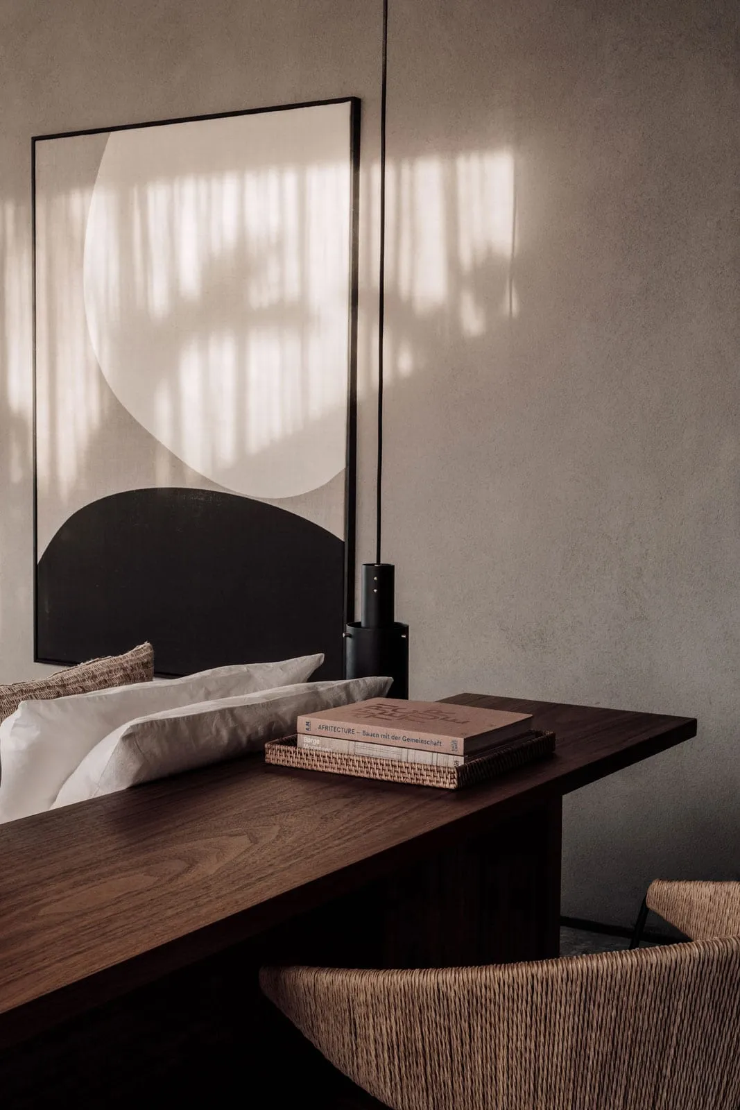Modern minimalist living space with a textured paper-covered worktable and a large abstract artwork featuring geometric shape