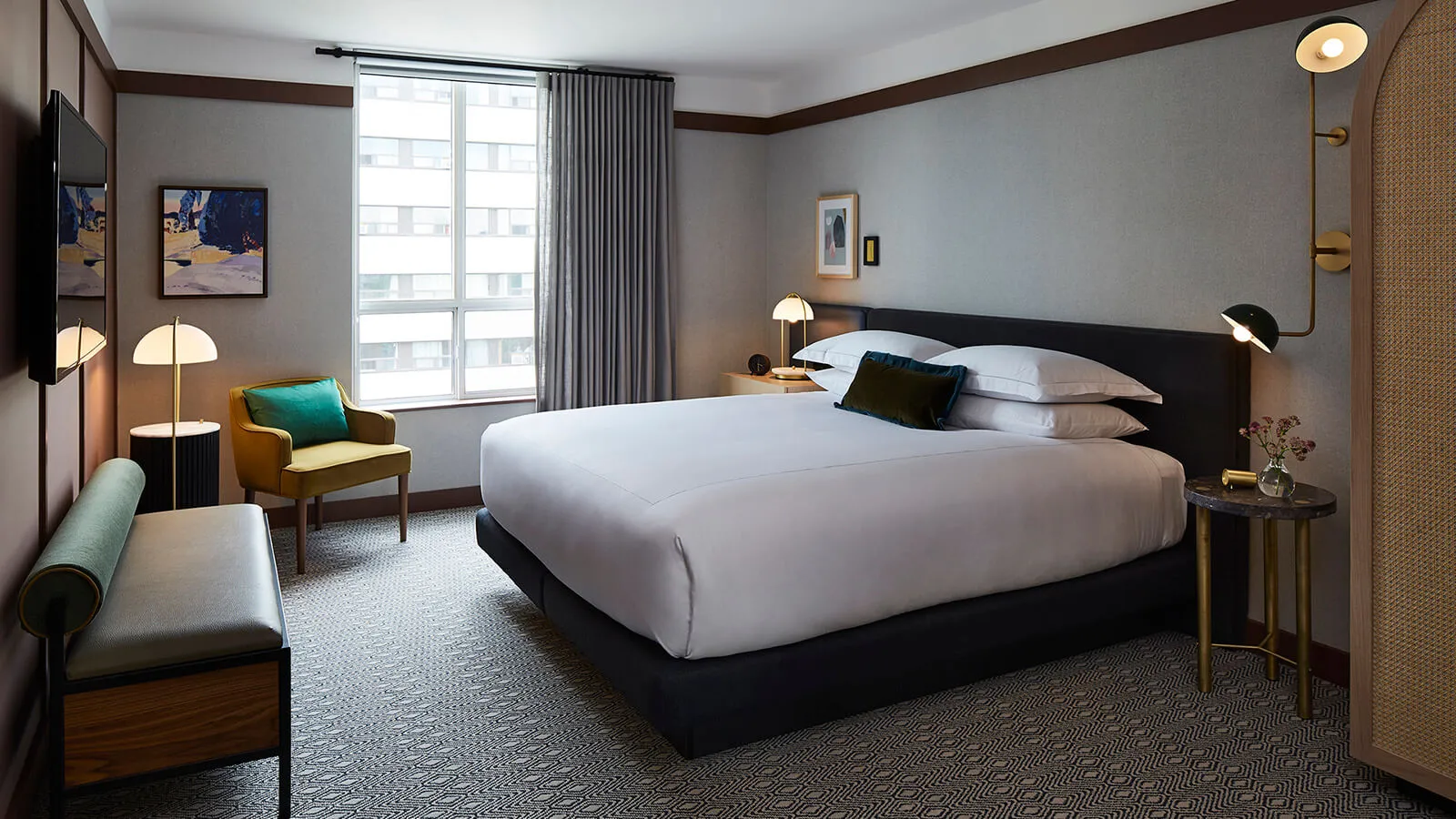 A well-designed, minimalist hotel room featuring modern furniture and textured fabrics.