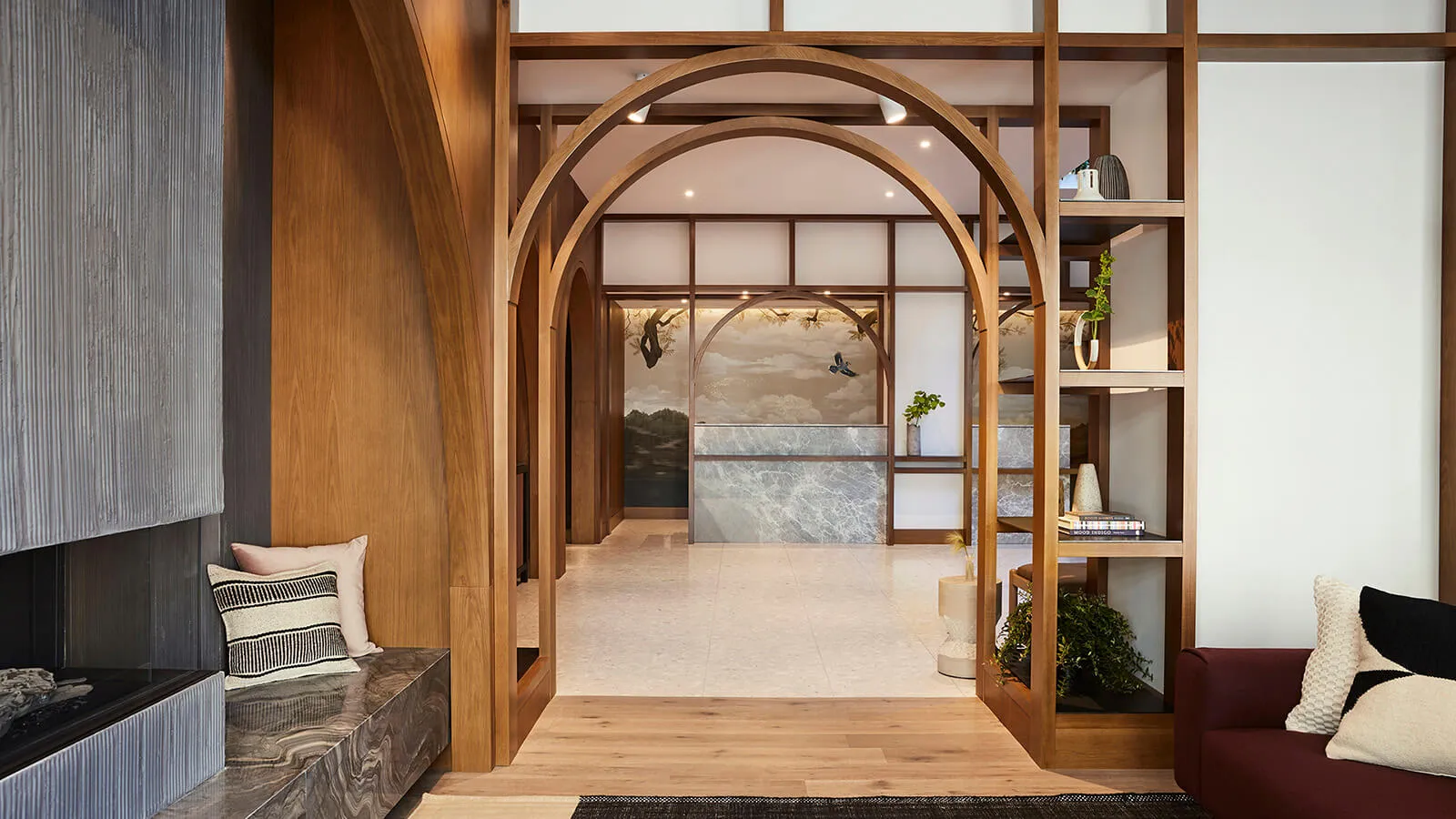 A modern interior design featuring wooden archways, with a cozy seating area and decorative elements.