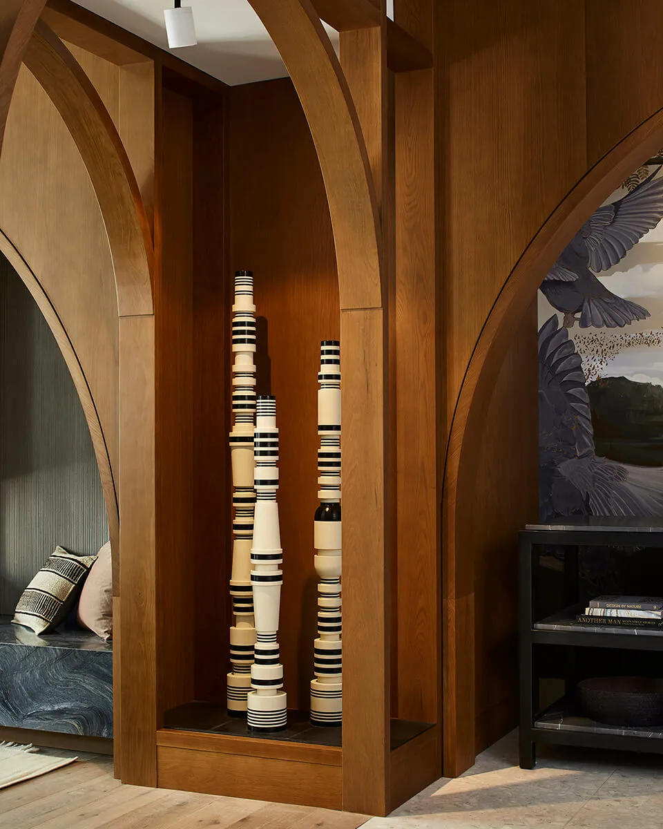 A modern interior design featuring wooden arches and a sculptural floor-to-ceiling installation.