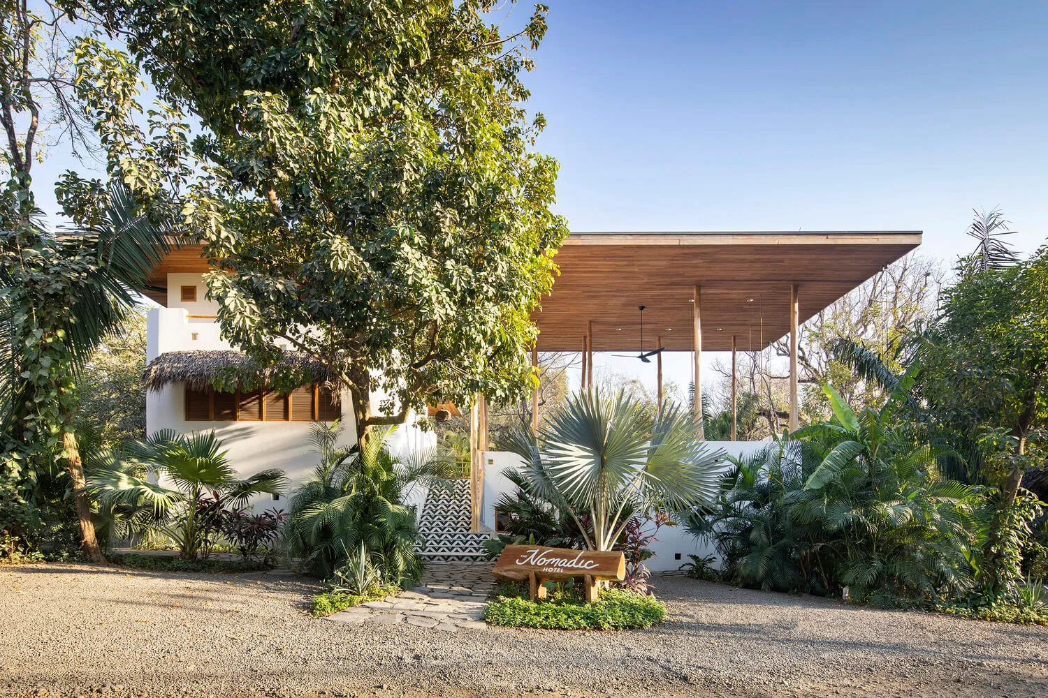 A modern residential exterior featuring concrete, stucco, and glass materials.