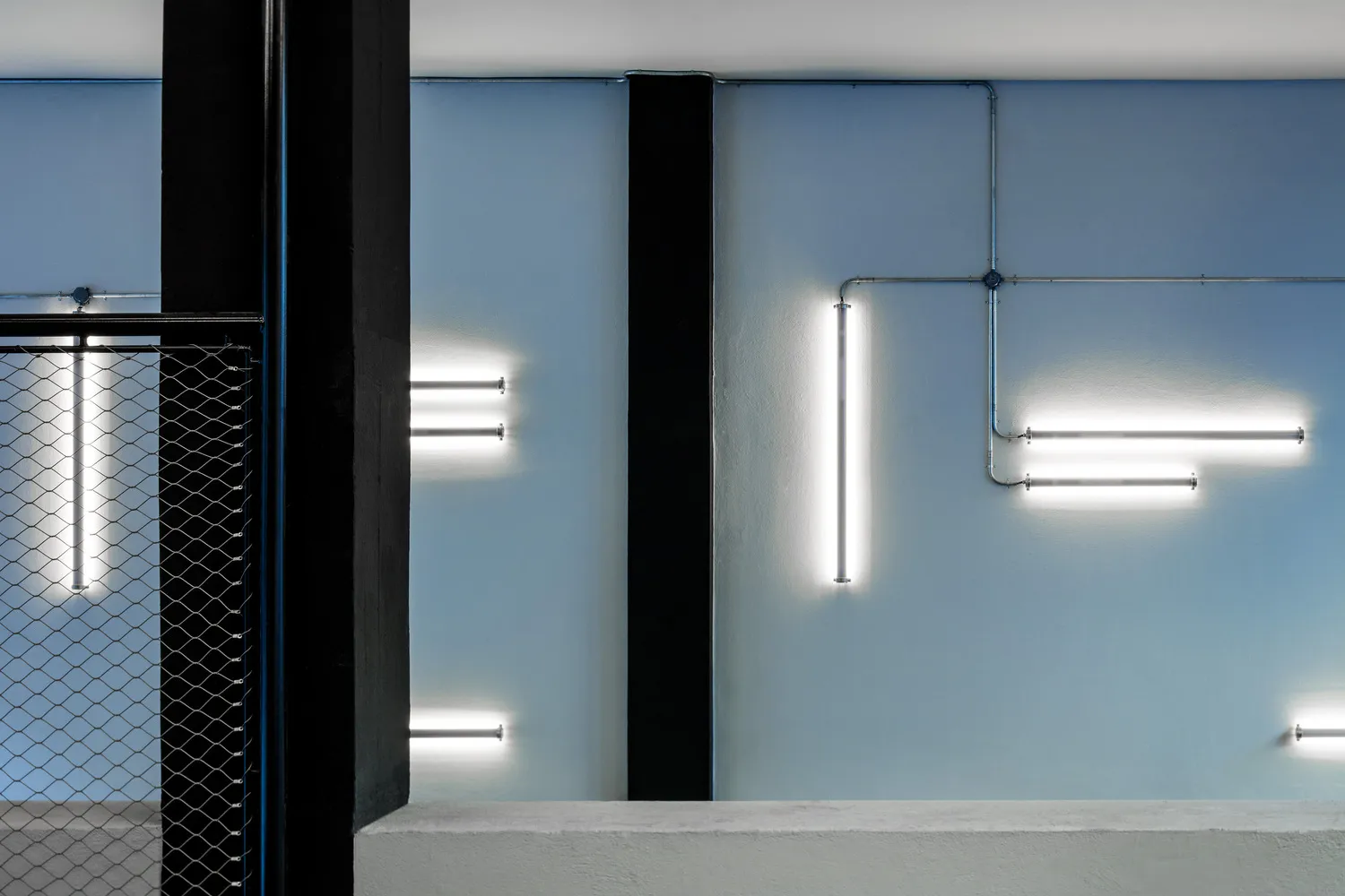 A minimalist interior design featuring concrete walls and lighting fixtures.