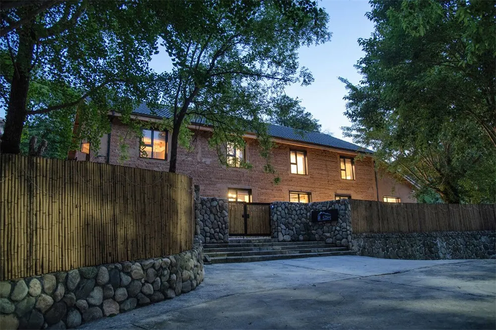 A brick house with a wooden fence and stone steps.