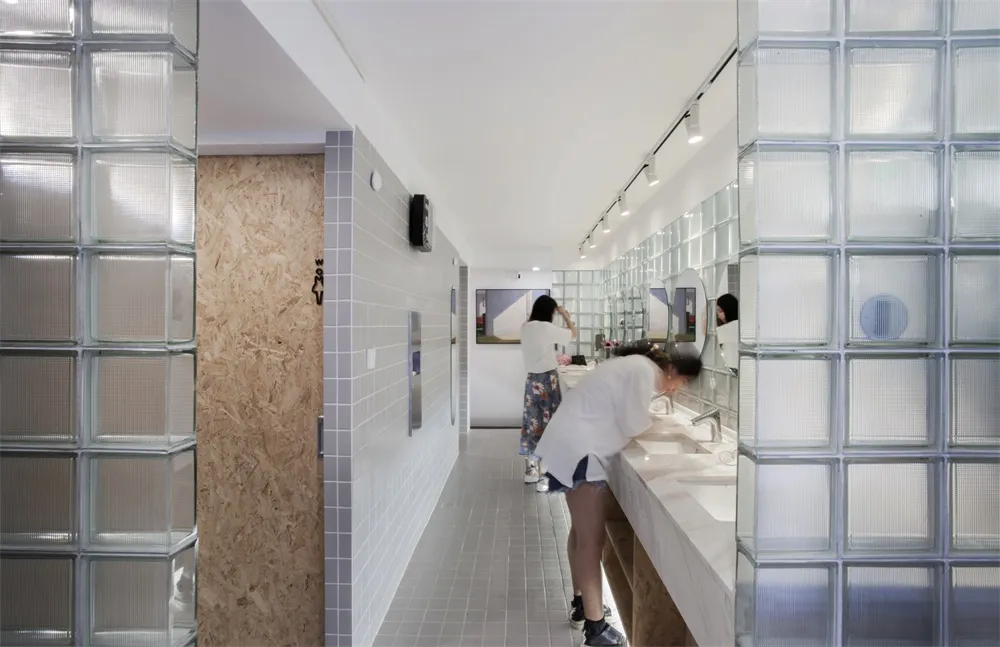 A minimalist public bathroom with glass blocks on the walls.