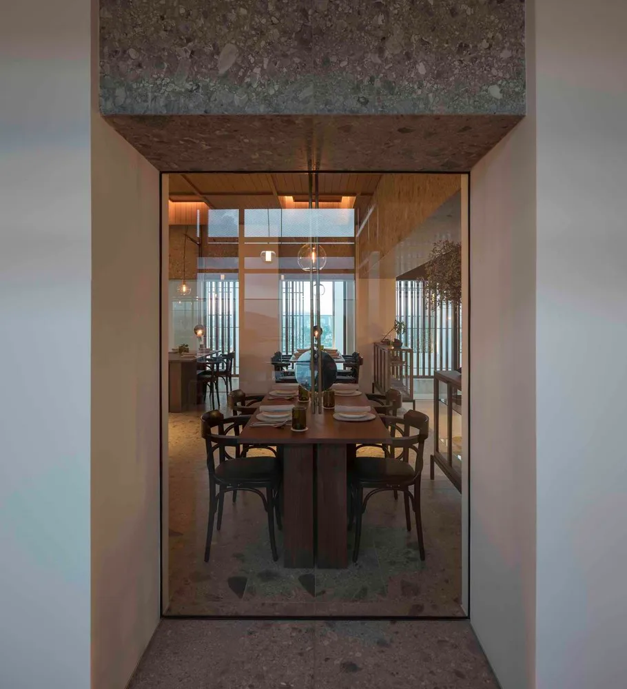 Modern dining room featuring wooden tables and glass walls.