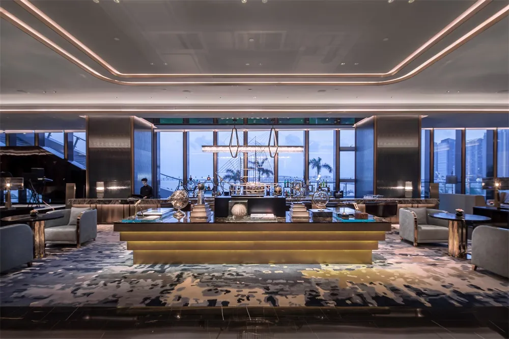 A modern hotel bar with glass, marble, and brass accents.