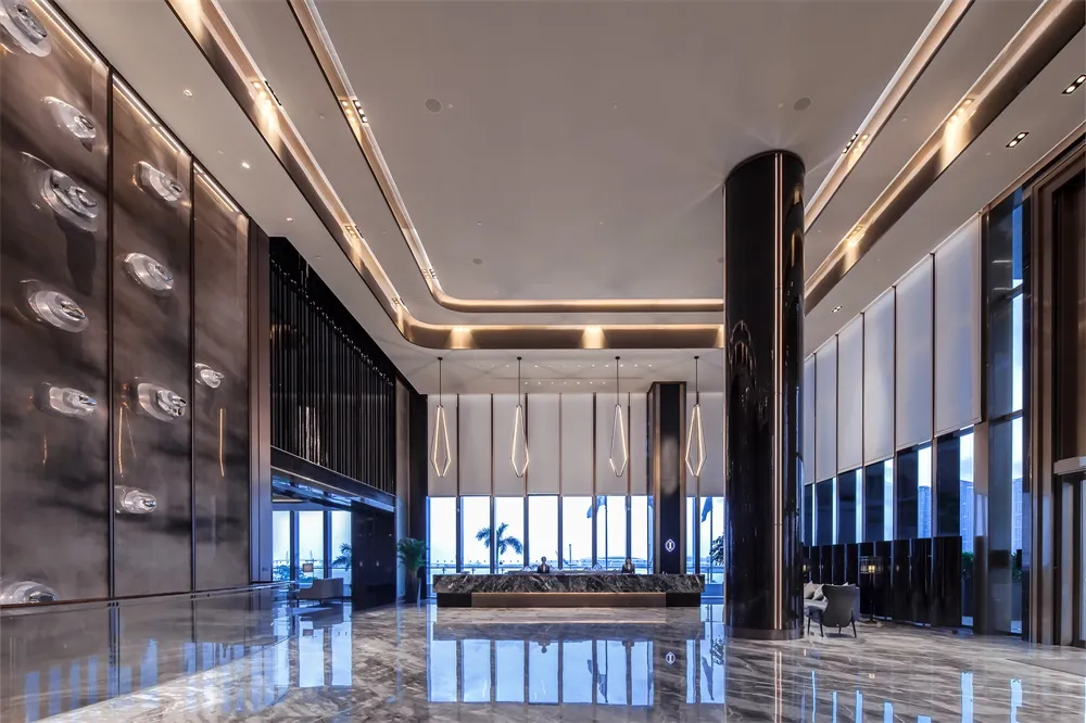 Modern hotel lobby featuring metallic bamboo accents and minimalist design.
