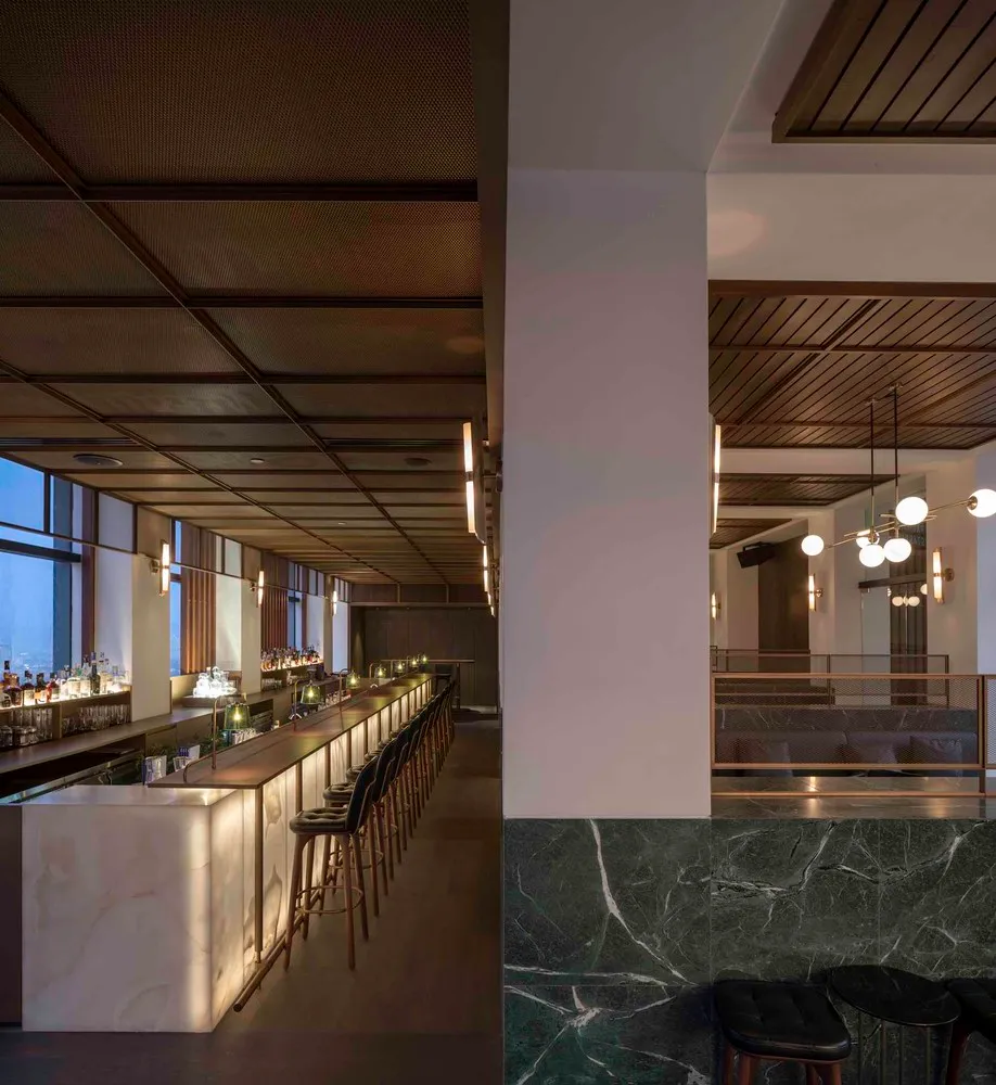 Interior view of a modern industrial restaurant bar featuring marble and concrete materials