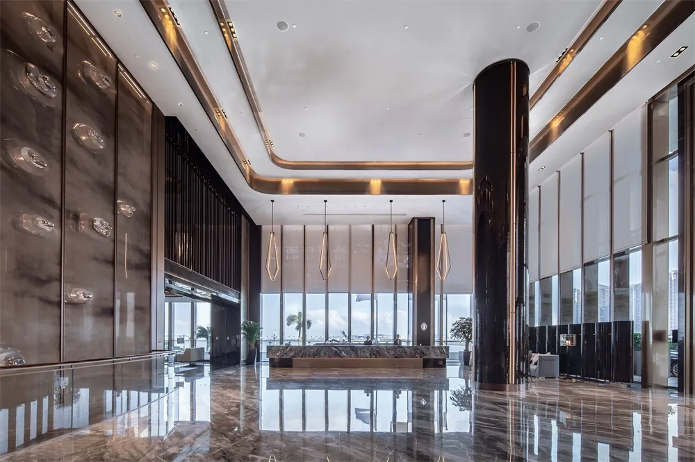 Modern lobby with marble flooring, glass walls, and metal accents